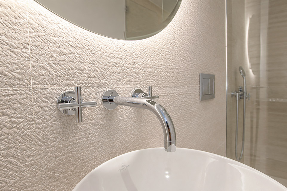 Detalle de lavabo y grifería empotrada en baño reformado del apartamento
