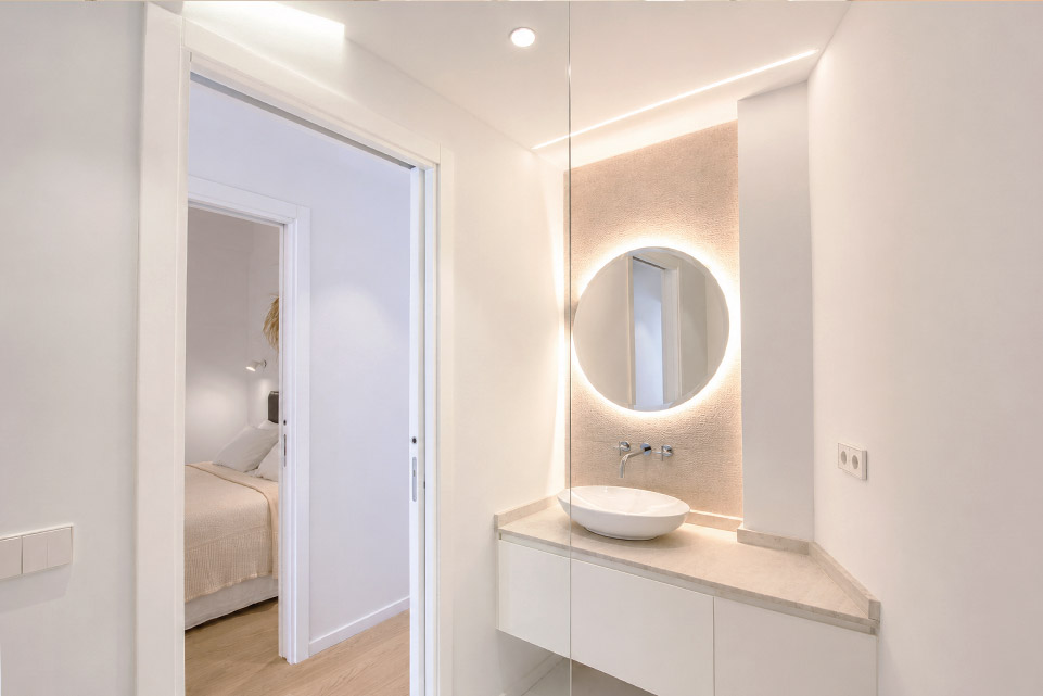 Lavabo a medida con espejo retroiluminado en reforma de vivienda en Palma