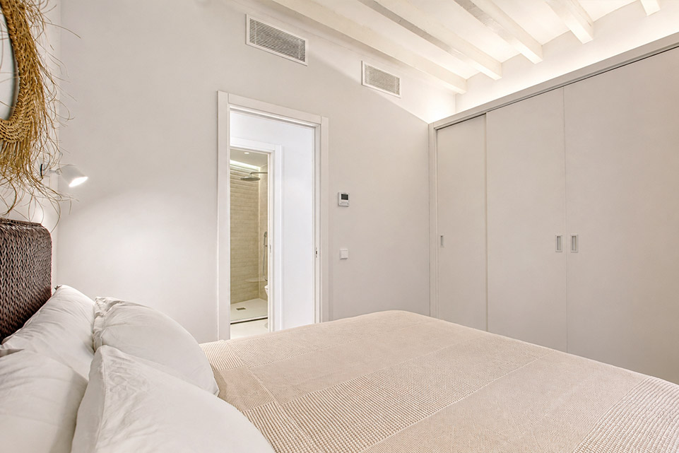 Dormitorio con armarios a medida y baño en suite en apartamento reformado en Palma