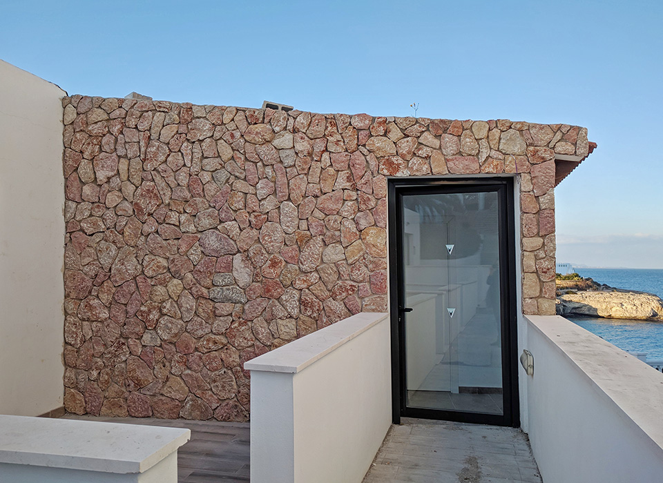 Revestimiento decorativo de piedra en pared exterior de hotel en Cala Murada Mallorca